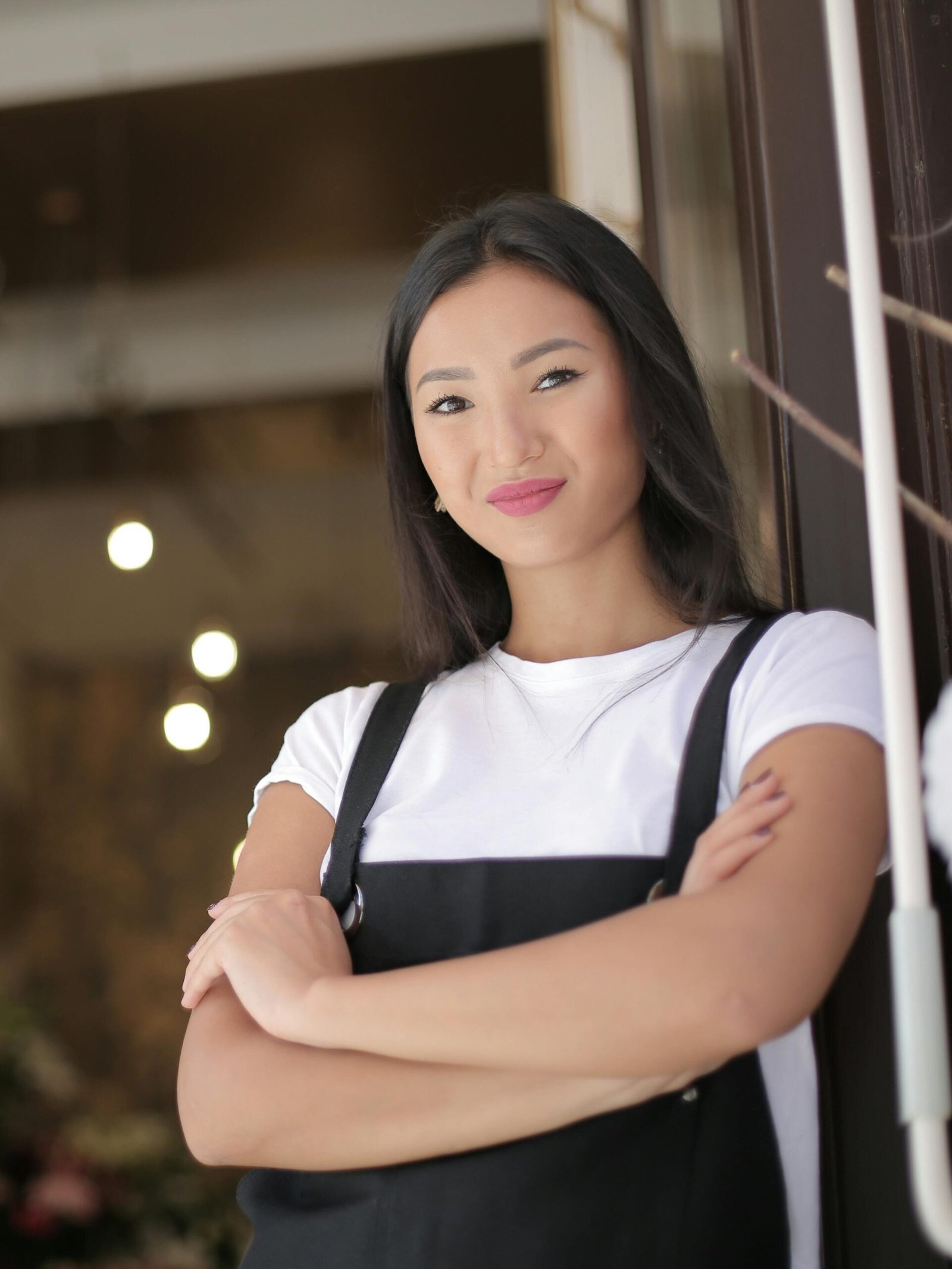 pexels-photo-3933017-3933017 Smiling female florist standing with arms crossed at shop entrance, exuding confidence and friendliness.